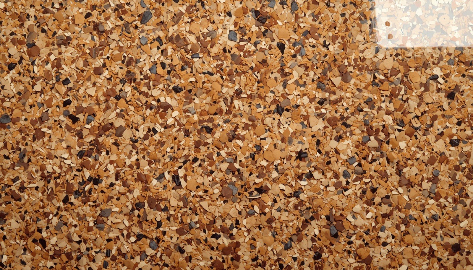 Decorative flake epoxy close up, saddle tan blend with tan, brown, beige, cream and black chips